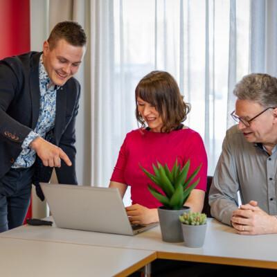 Mies esittelee kannettavalta tietokoneelta työelämässäoppimisen hyötyjä kahdelle henkilölle.